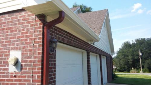 Gutters with red downspout to blend in with red brick